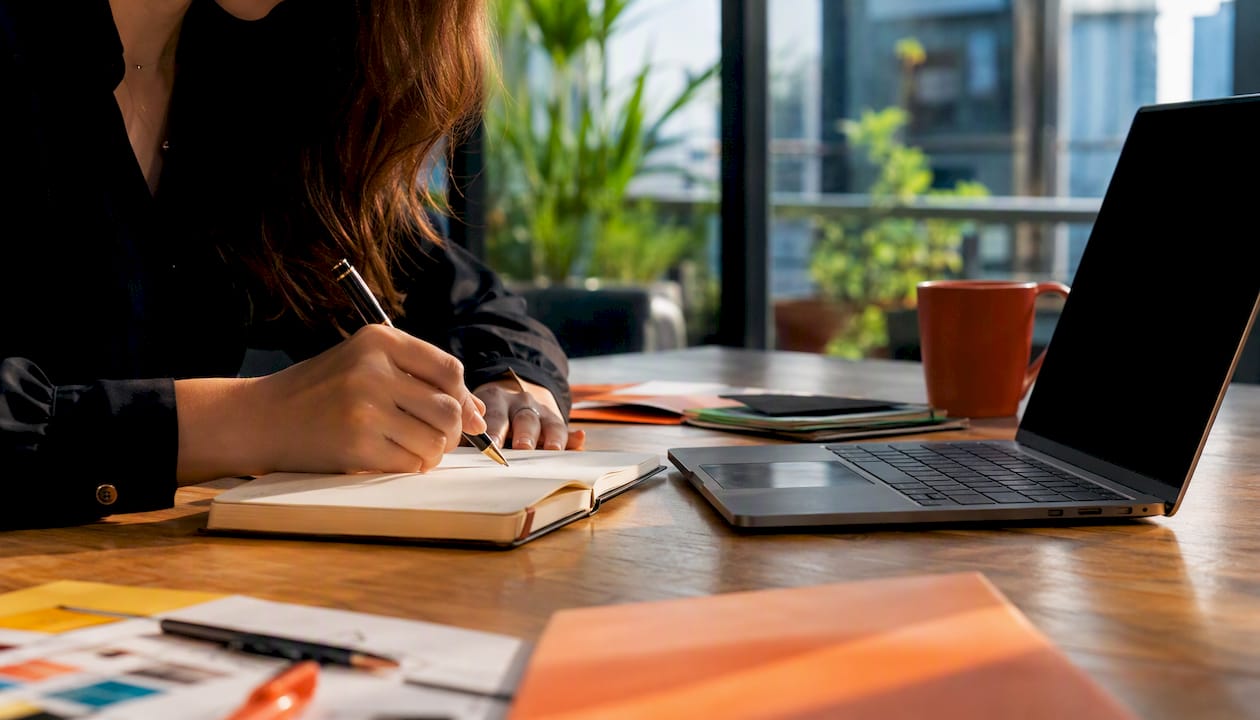 Hands writing marketing notes at desk