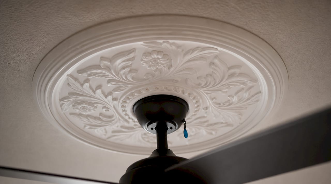 Close-up of decorative ceiling medallion and fan