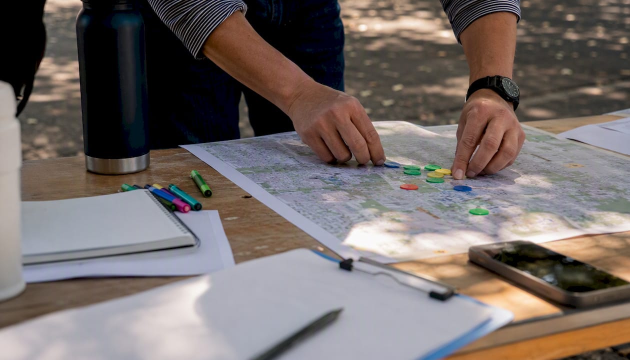 Hands marking community map with tokens
