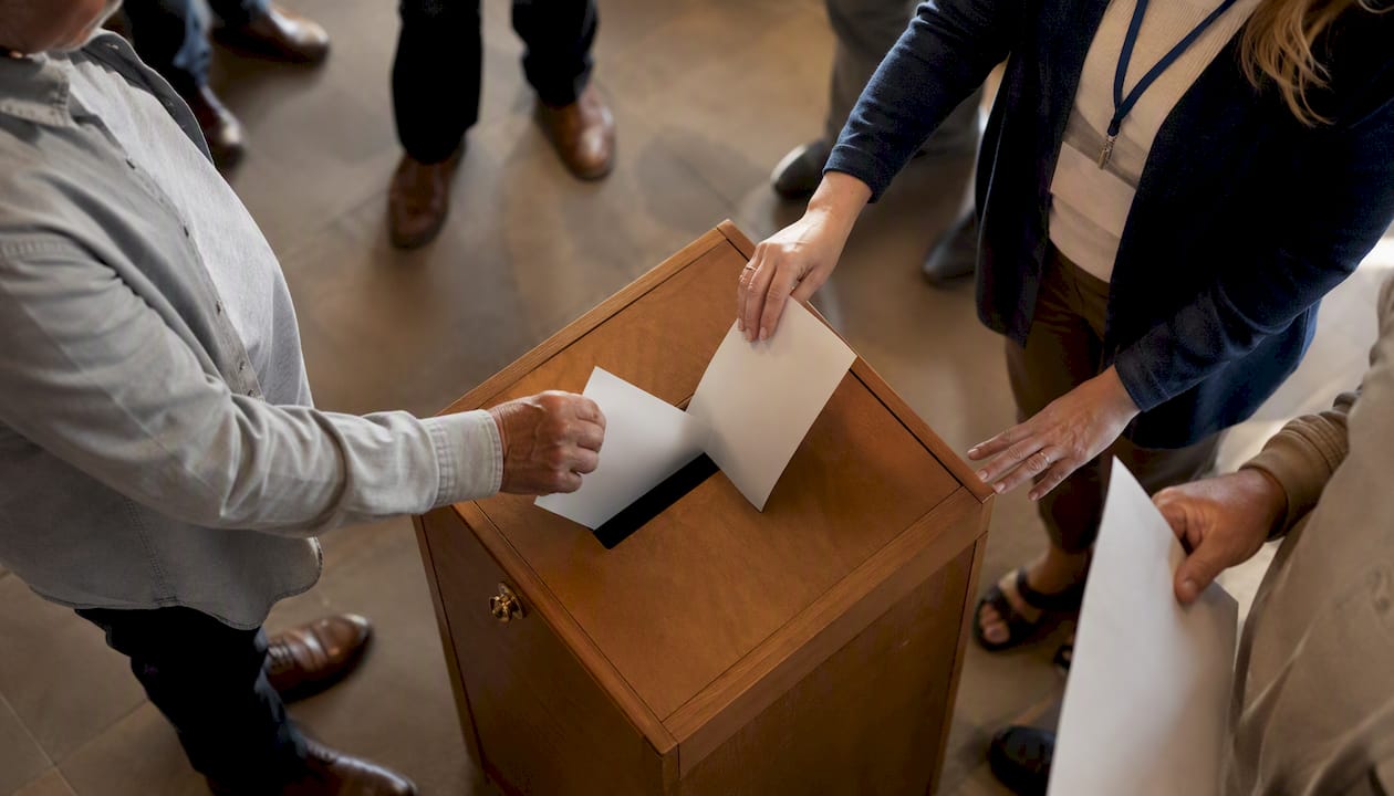 Hands casting ballots at polling station