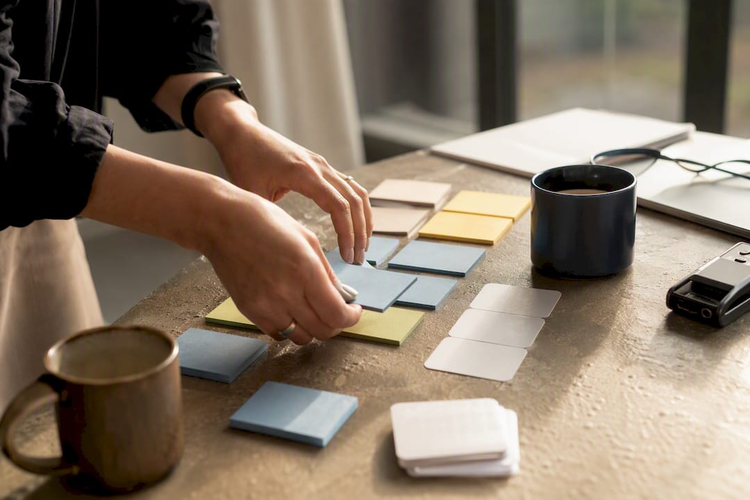 Hands arranging sticky notes for workshop prep
