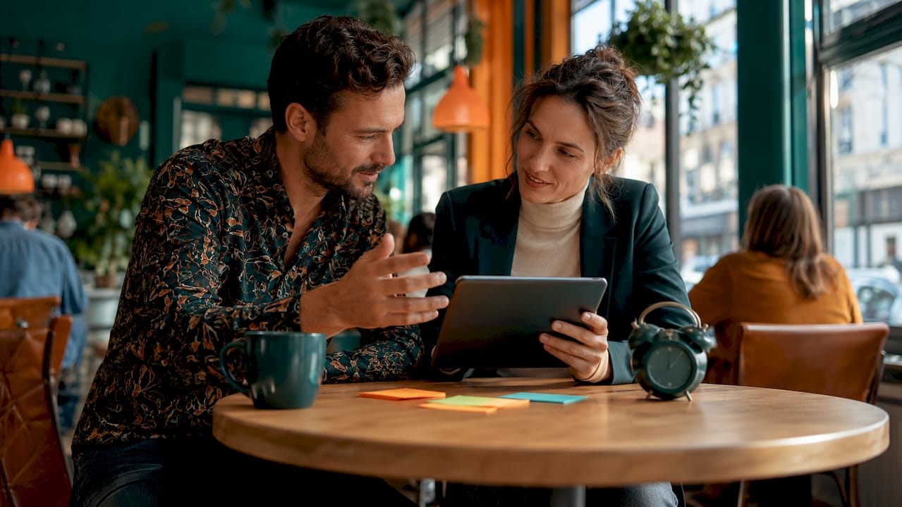 Two professionals discussing website crawling on tablet