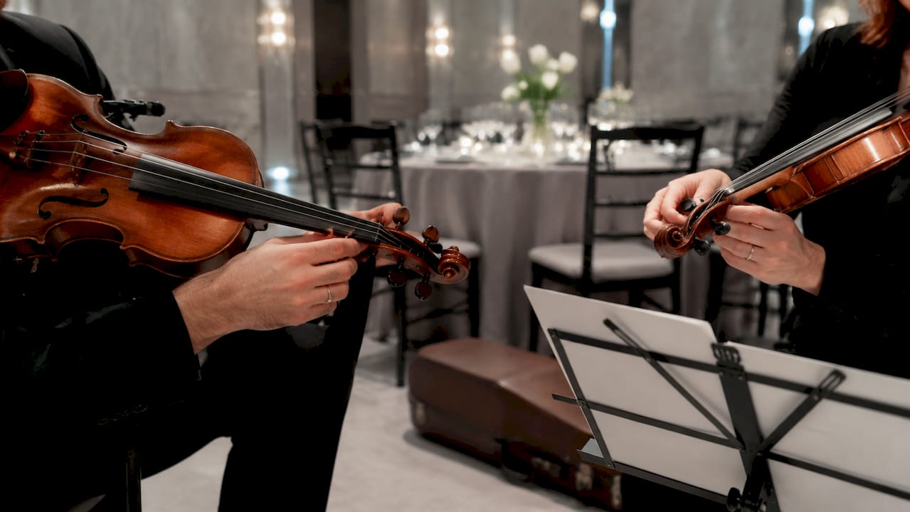 Close-up of string musicians tuning instruments