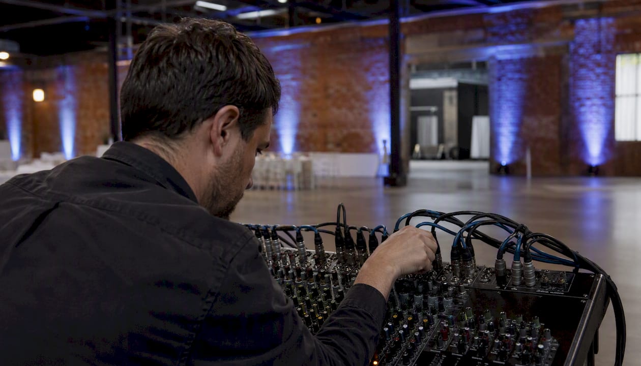 Hand connecting audio cables to mixer