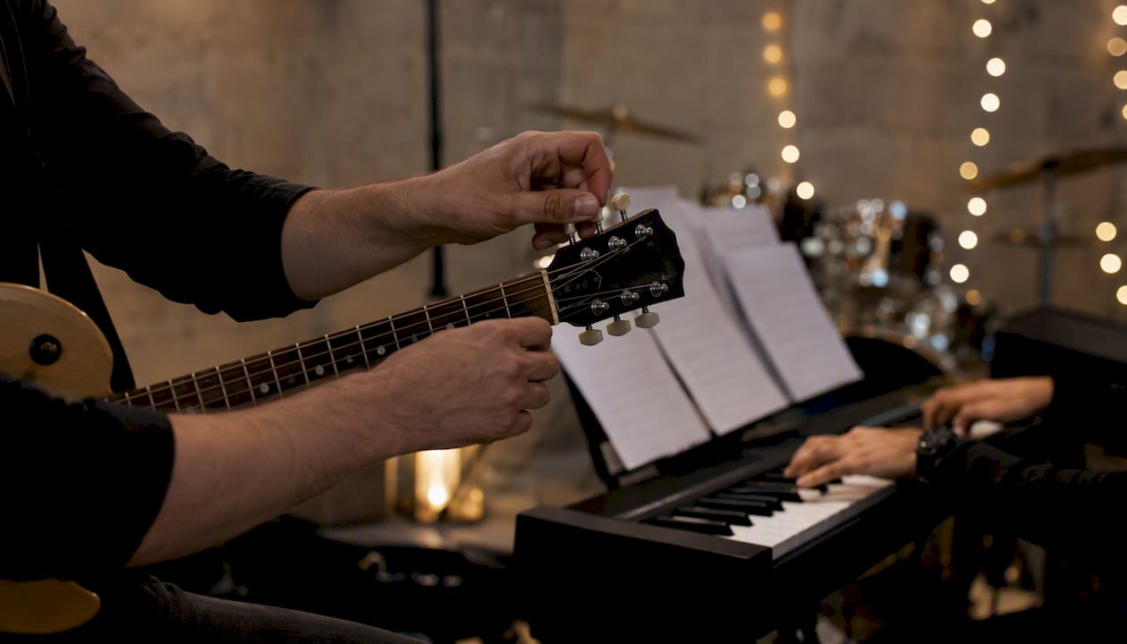 Hands on guitar and keyboard preparing medley