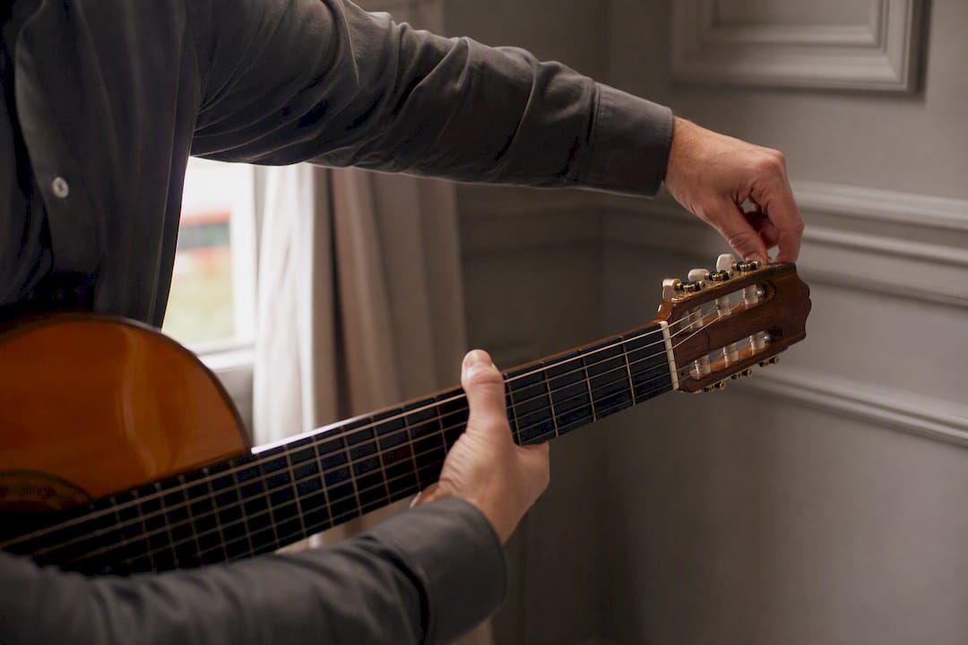 Hands tuning guitar strings at wedding venue