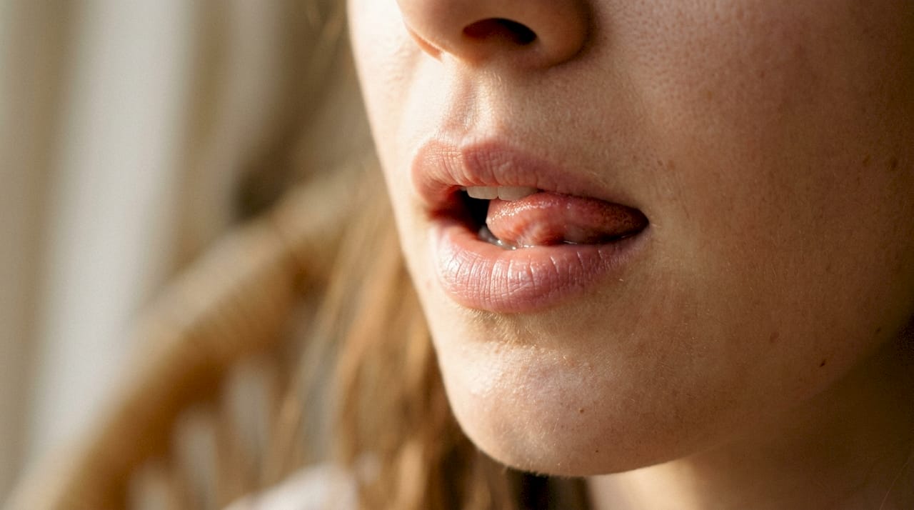 Tongue licking dry lips close-up