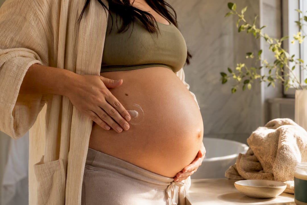 Pregnant person moisturizing dry belly skin
