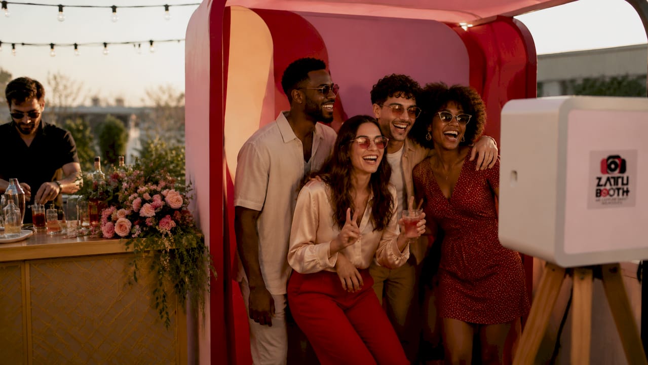 Guests posing inside an open-air photo booth near bar