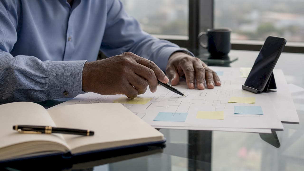 Hands pointing at governance flowchart with notes
