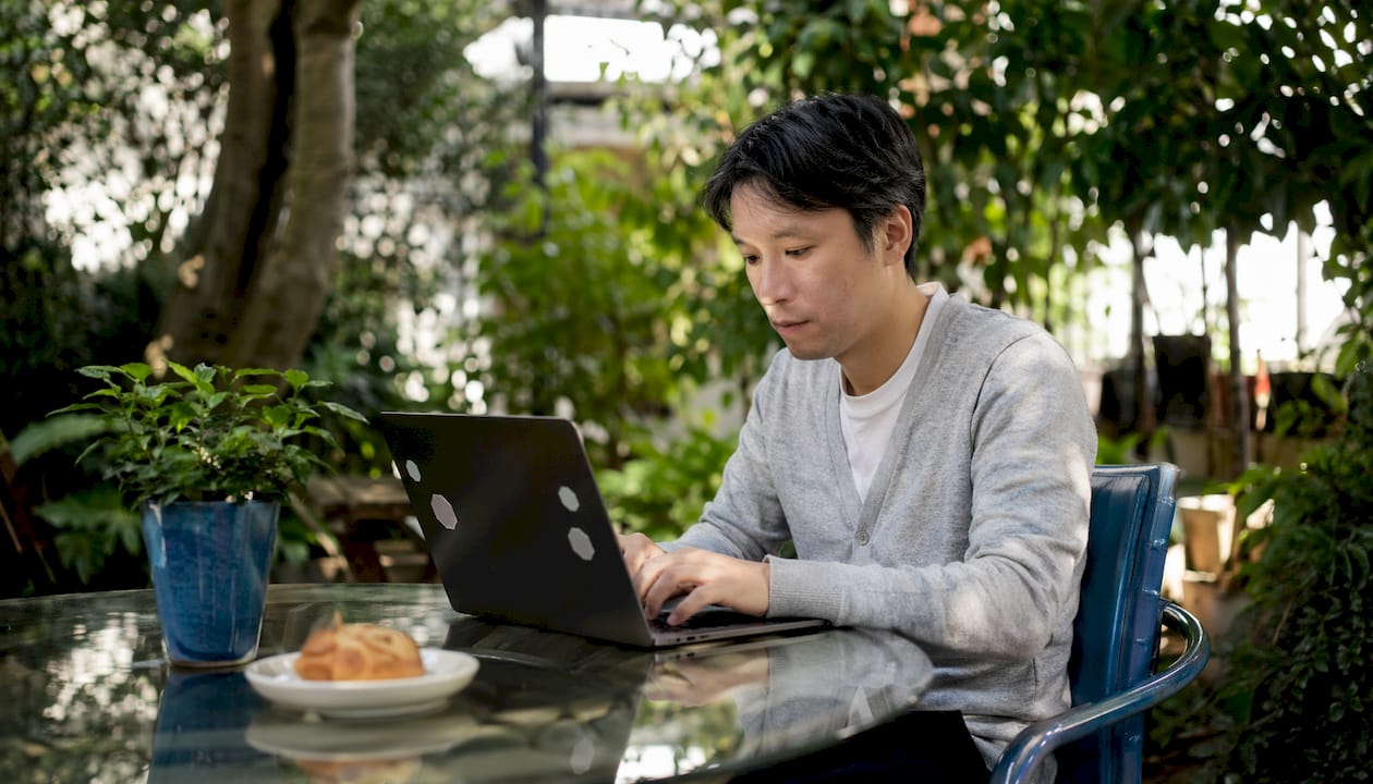 Hands typing on laptop in co-working space