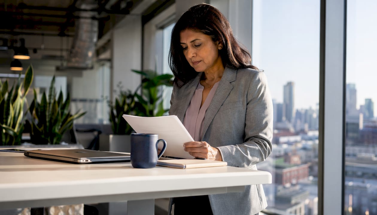 Leader reviewing daily briefing notes in office