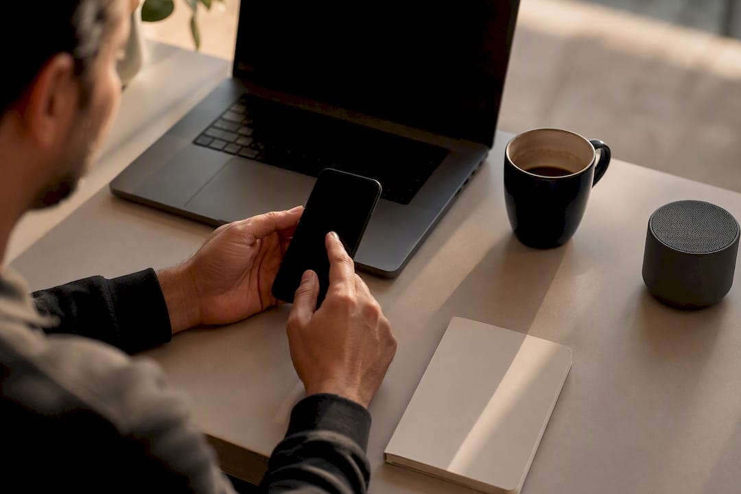 Hands setting smartphone alert on desk