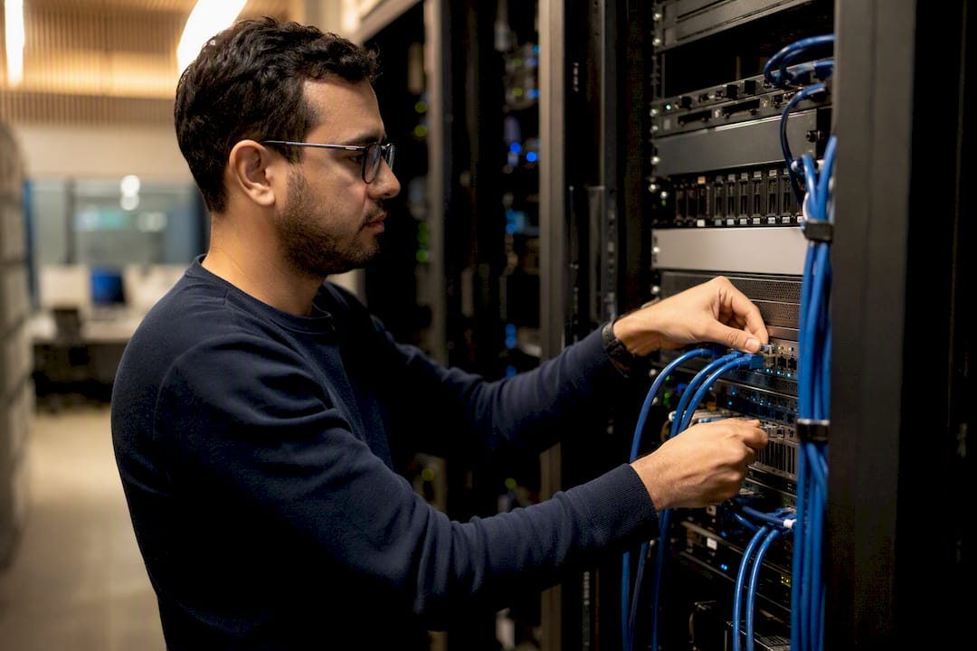 Hands connecting data cables in server room