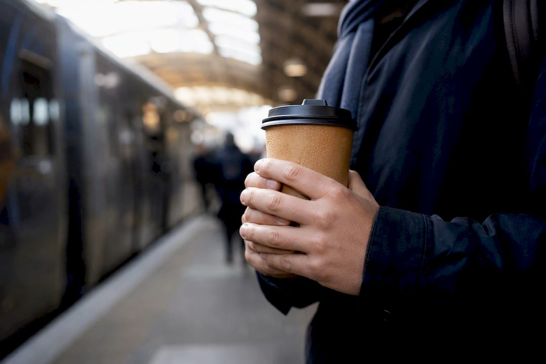 Hands holding coffee cup on bus