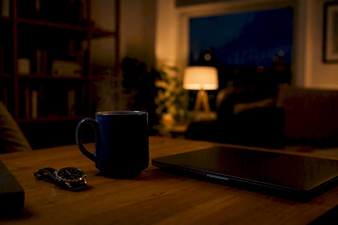 Late-night workspace with watch and coffee mug