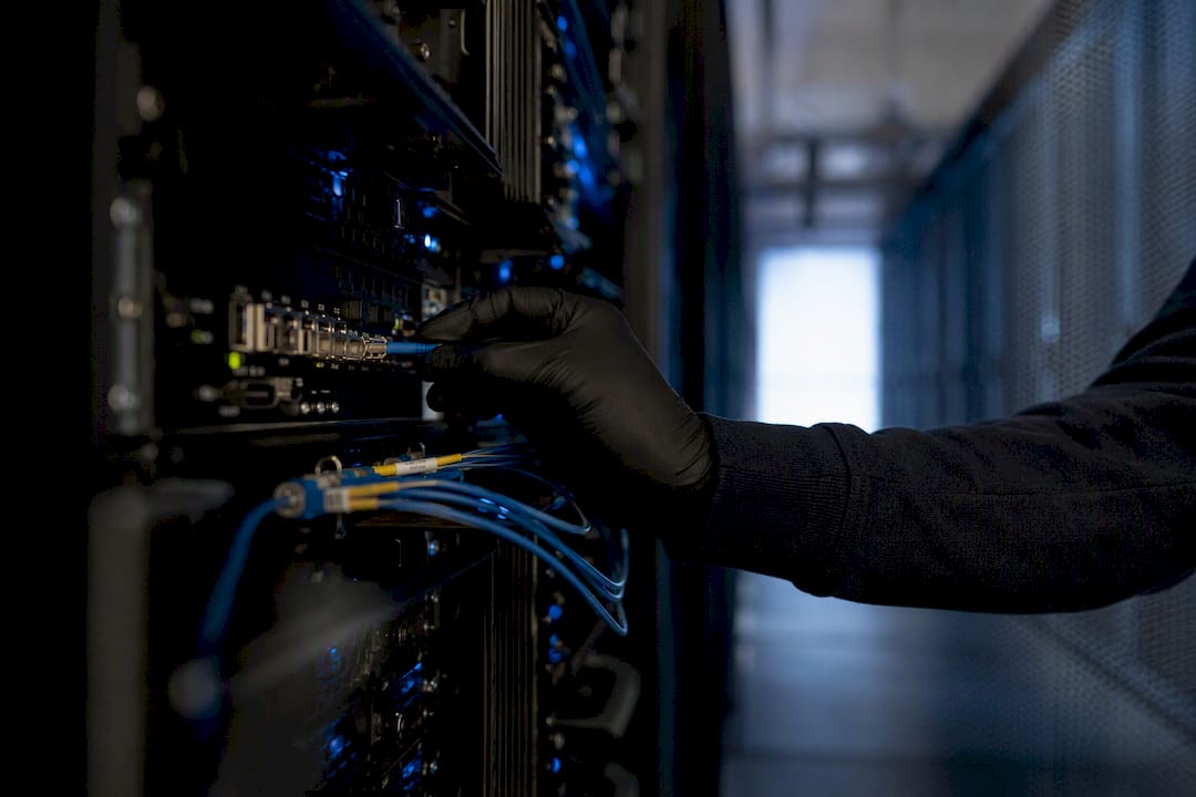 Technician plugging cable in server room