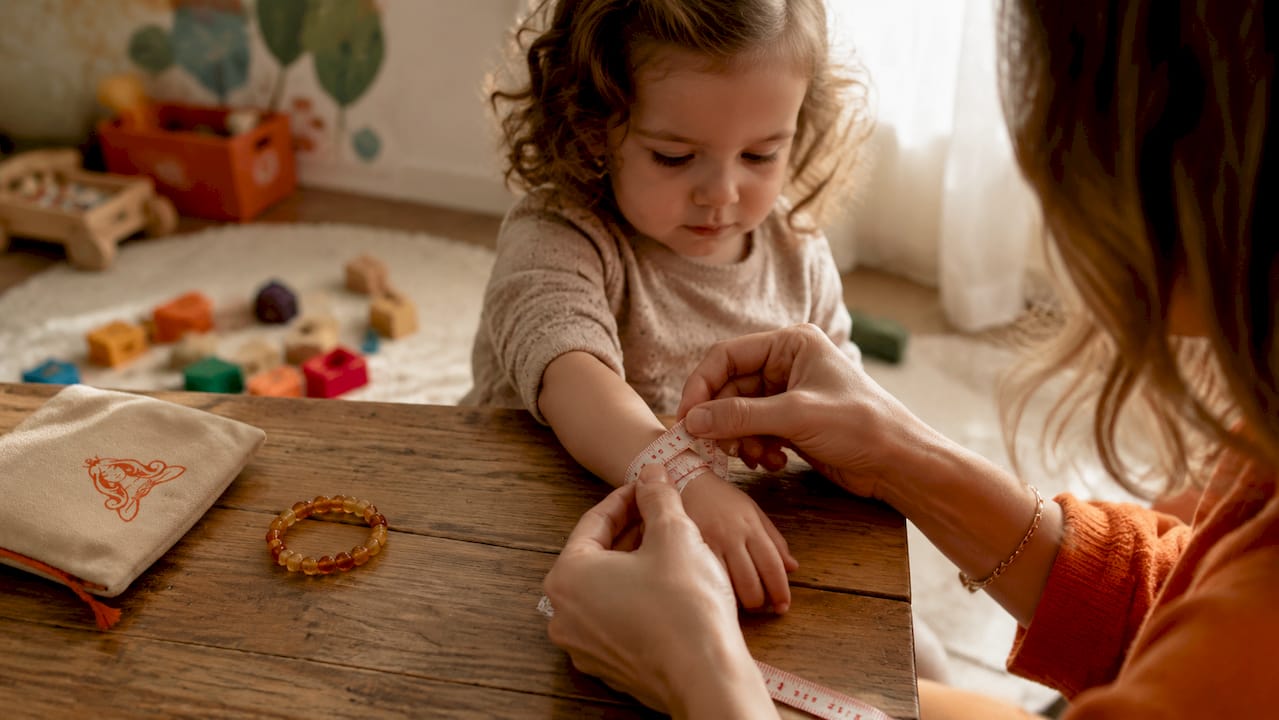 Close-up of hands measuring toddler wrist