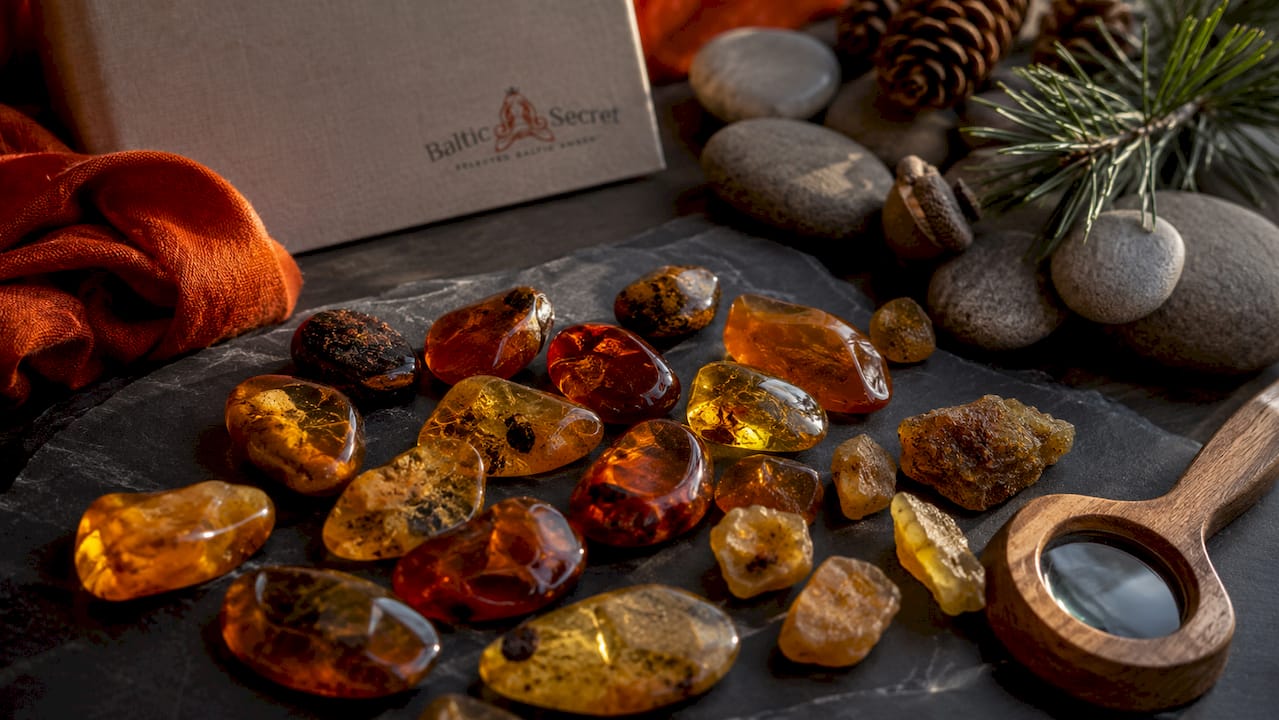 Polished cognac amber stones on wooden table
