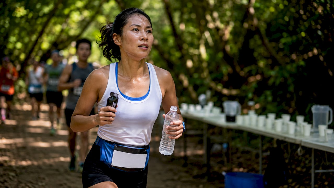 Runner fueling with energy gel and water during marathon