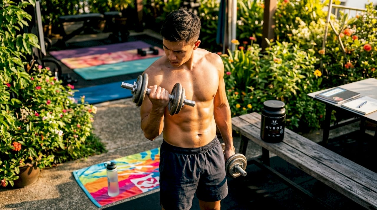 Close-up of athlete gripping dumbbell in gym