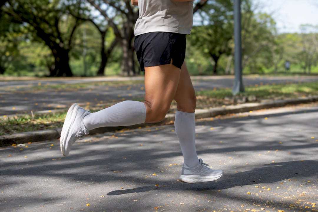 Runner jogging wearing light compression socks outdoors