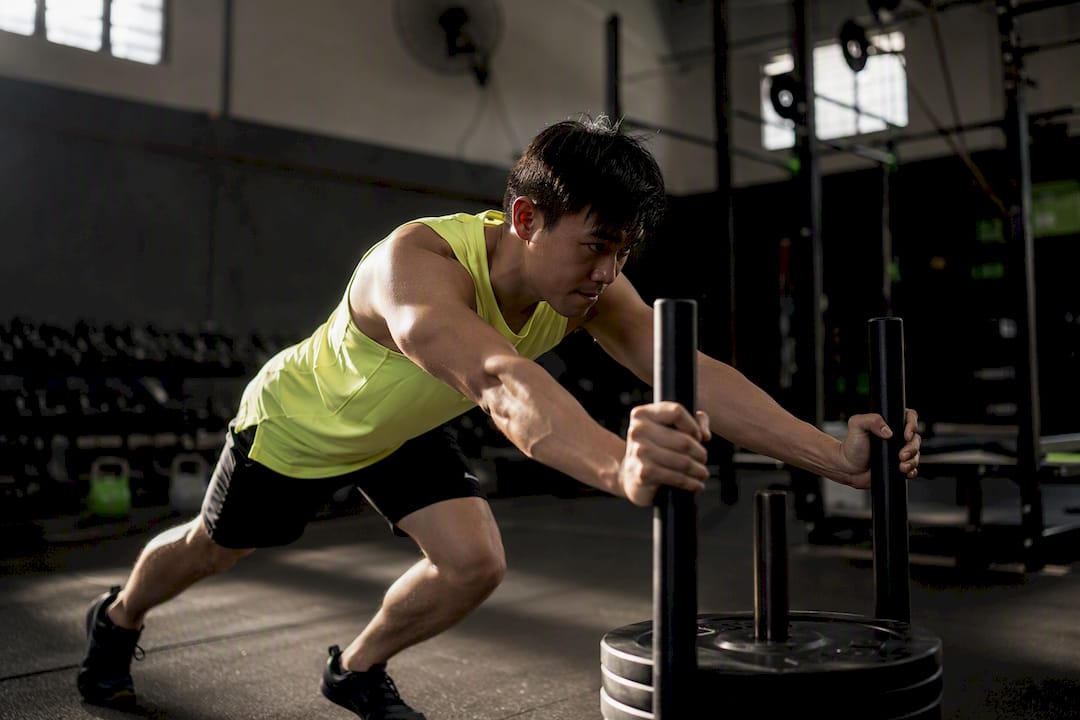 Athlete pushing sled focusing on core bracing