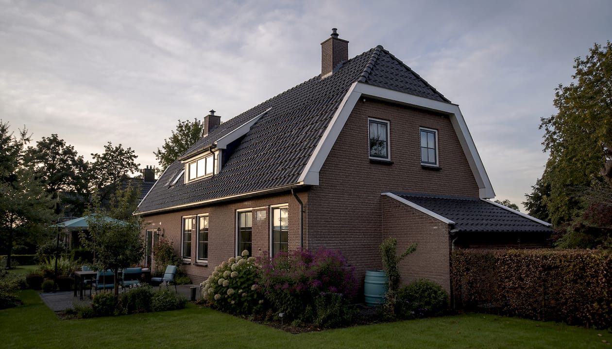 Zijaanzicht van een woning met een karakteristiek wolfseind dak