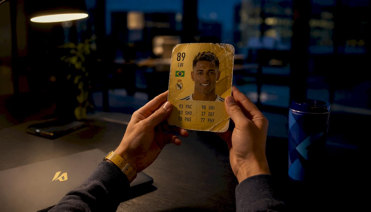 Hands holding FIFA player card examining attributes
