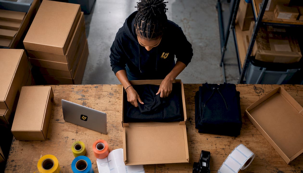 Hands packing sports club apparel in boxes