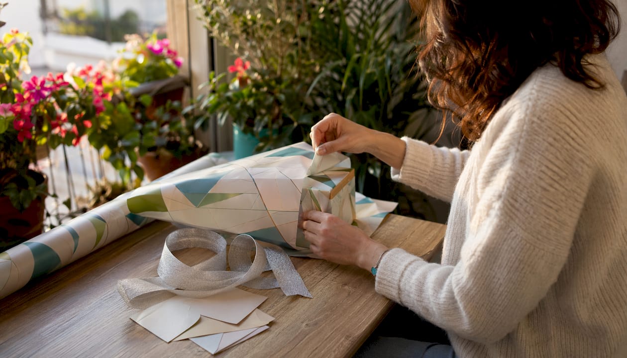 Hands wrapping personalized perfume gift packaging