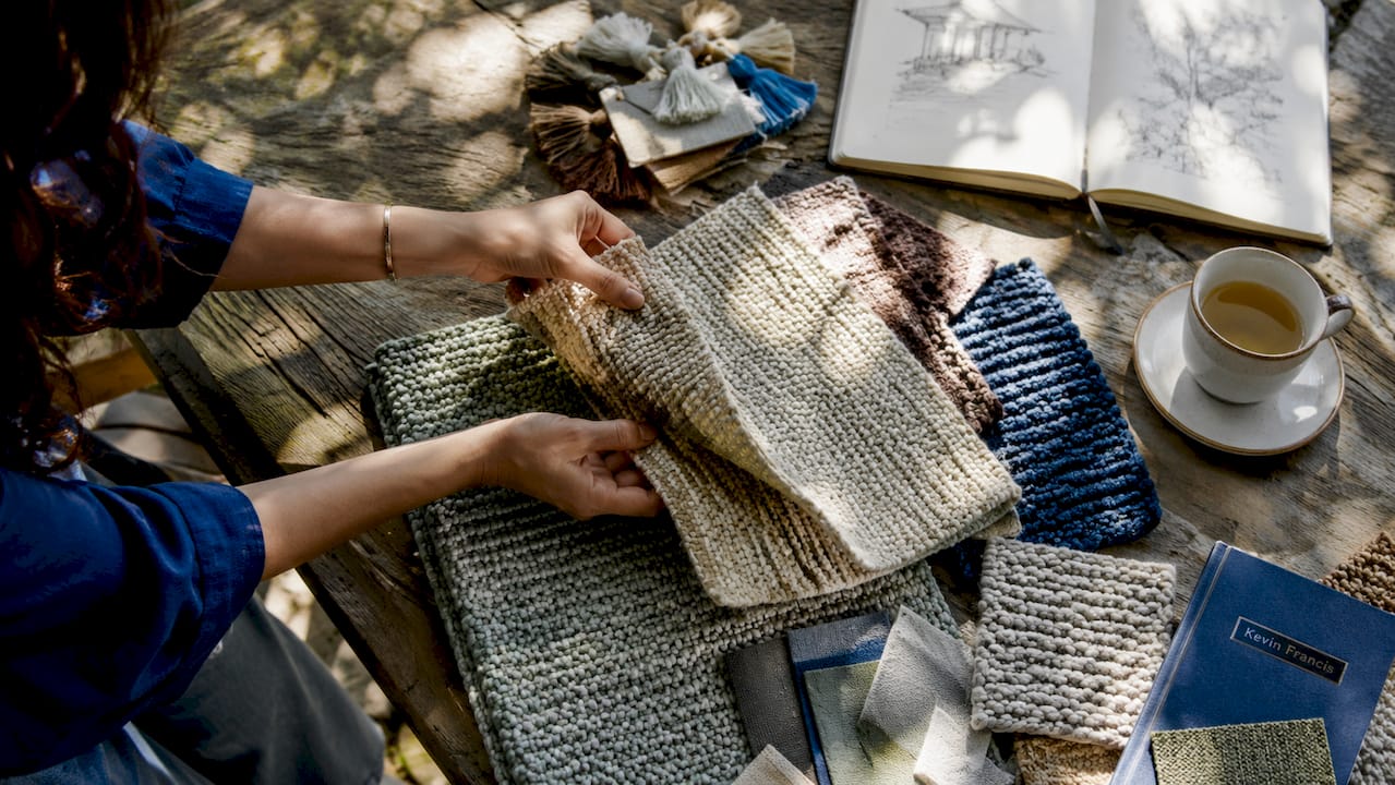 Hands with wool and cotton rug samples