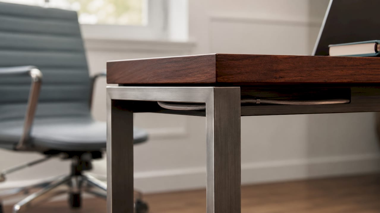 Close-up of hardwood desktop and steel desk leg