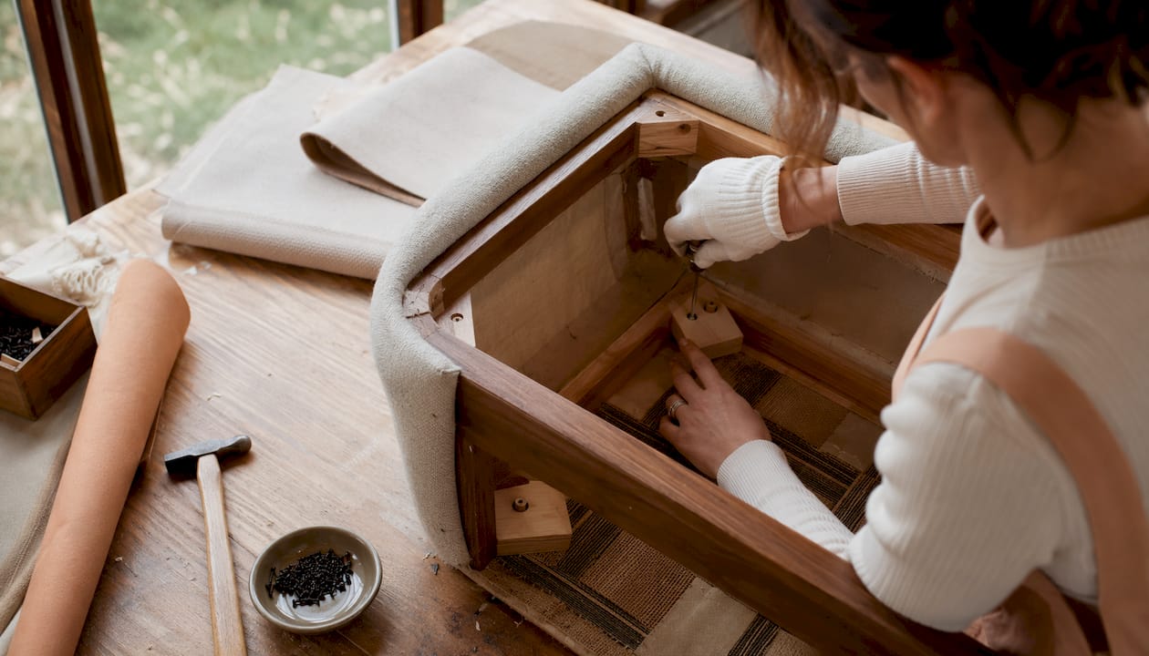 Hands attaching corner blocks to sofa frame