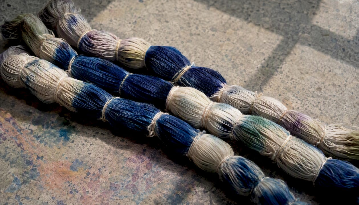 Resist-dyed ikat yarn bundles on table