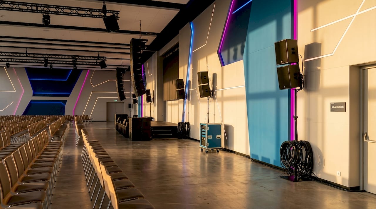 In deze ruime zaal zijn extra speakers geplaatst om het geluid overal goed hoorbaar te maken.