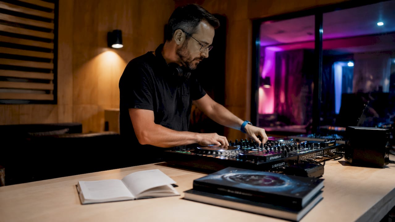Een paar handen houdt een garantiebewijs vast naast een DJ-mixer.