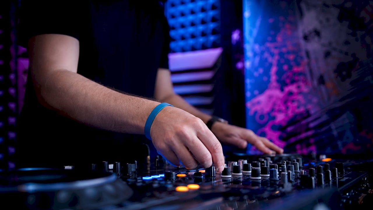 Handen draaien aan de knoppen van de BOOTH-mixer om het geluid af te stemmen
