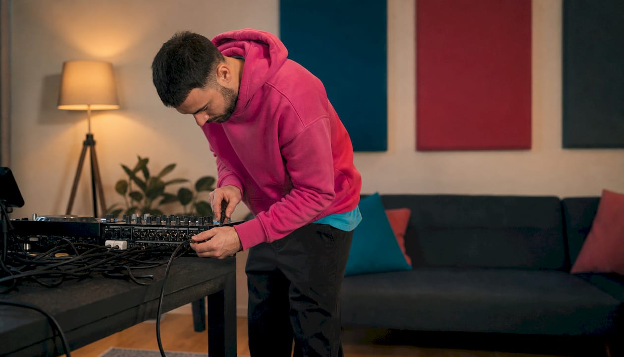 Iemand sluit een XLR-kabel aan op een mengpaneel.