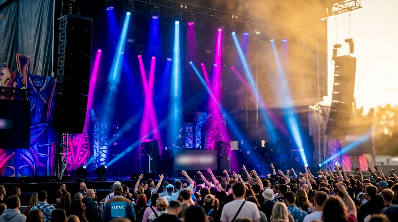 Felle lichtstralen dansen door de nevel op het podium.