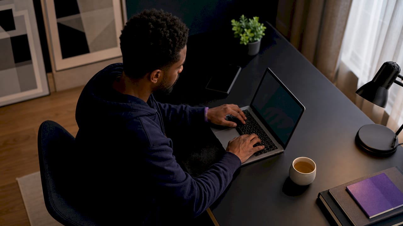 Man typing AI instructions in coworking space