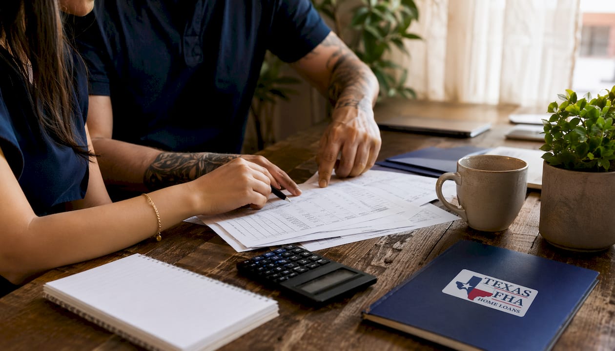 Hands calculating mortgage income with documents and calculator