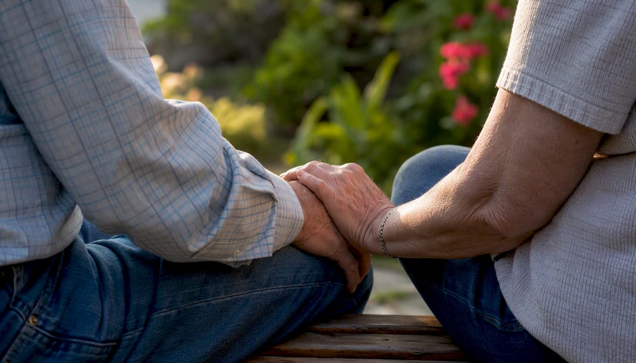 Senior couple holding hands in garden