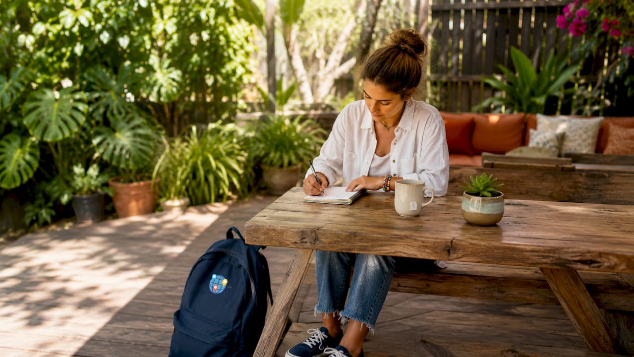 Hands noting travel constraints in notebook