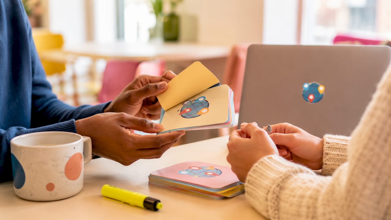 Hands using flashcards in library study area