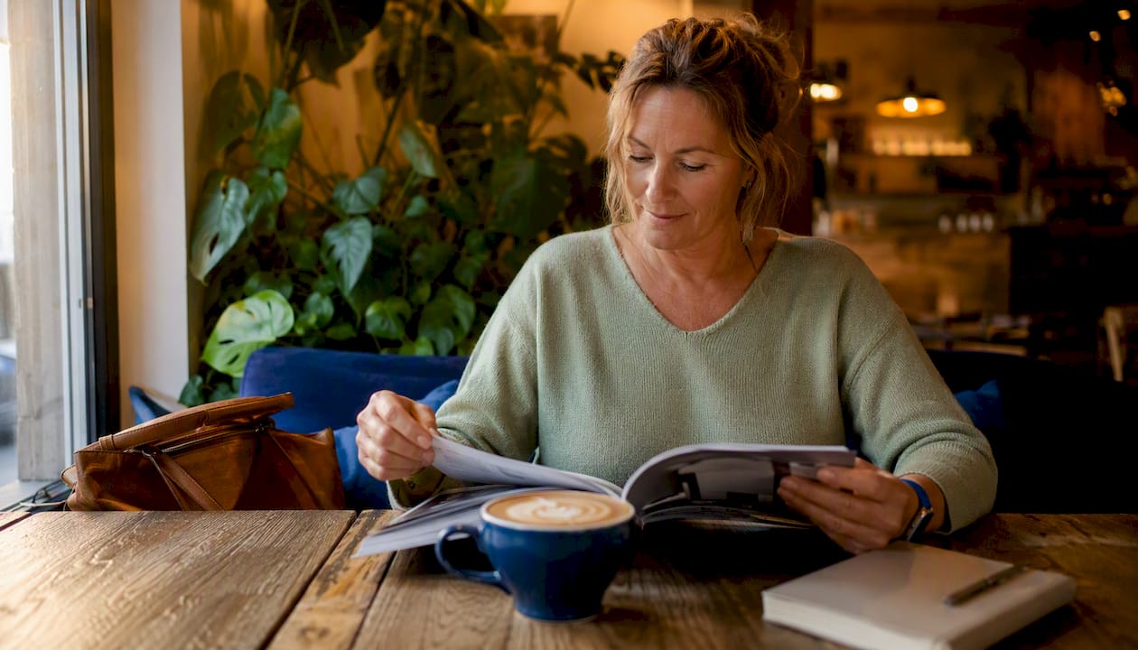 Vrouw vergelijkt refurbished aanbieders terwijl ze in het café zit