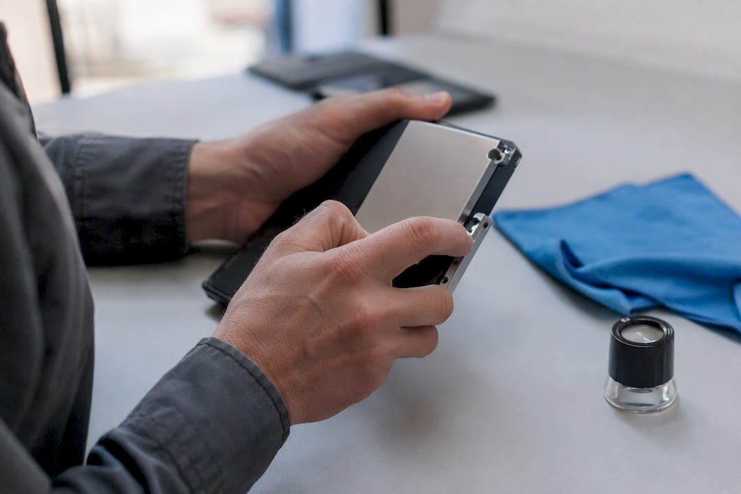Handen die onderdelen van een elektronisch apparaat bekijken