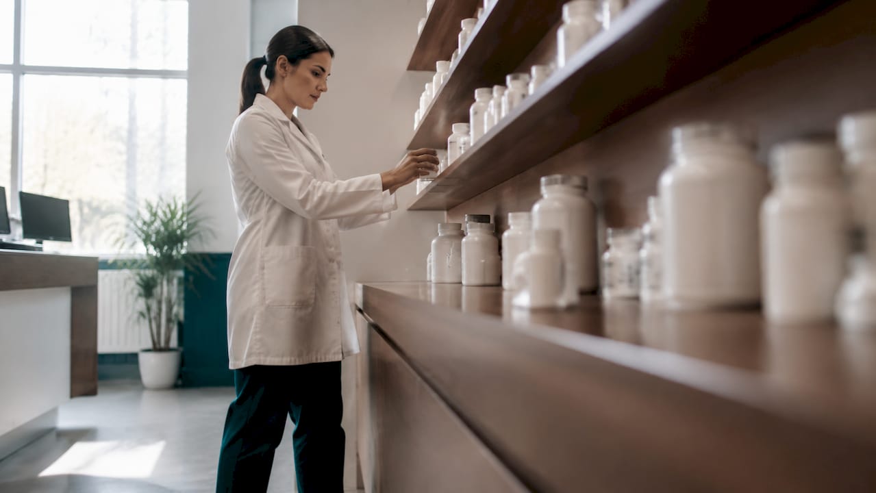 Pharmacist handling prescription bottles
