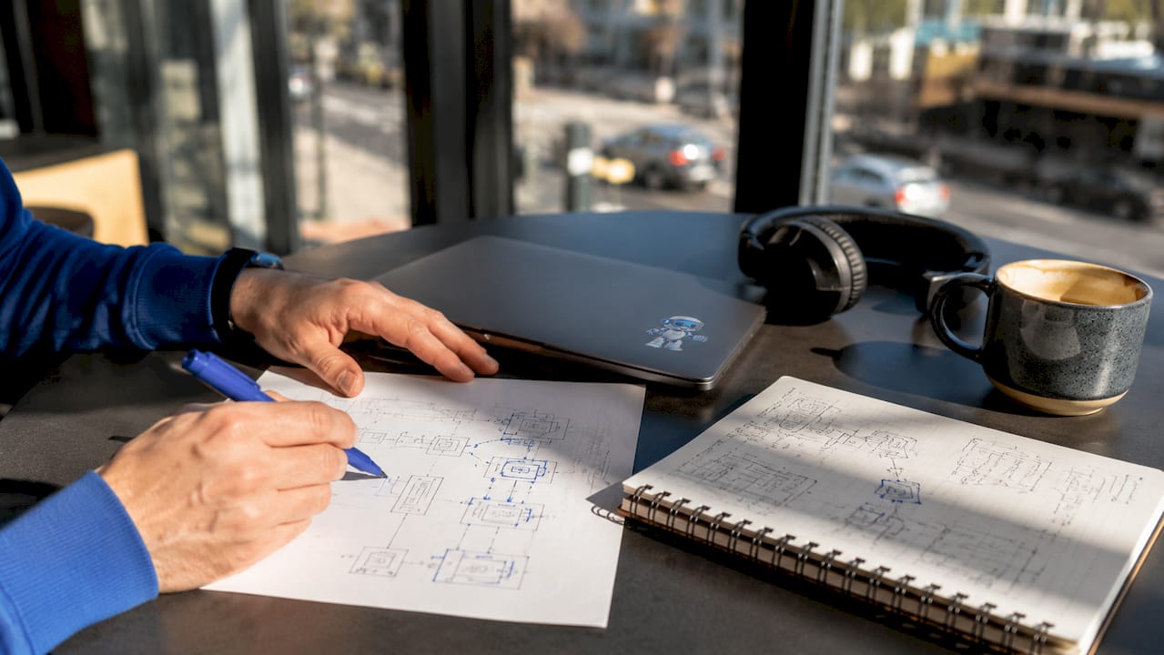 Developer pointing at UML interface symbols on paper