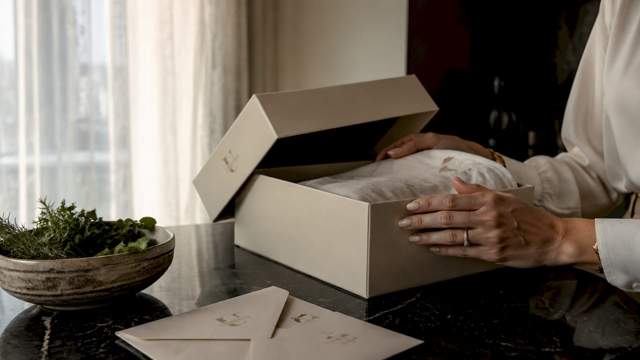 Hands photographing designer shoe box for authenticity check